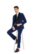 Load image into Gallery viewer, Sitting pose in men's royal blue velvet 3 piece suit with black shawl collar – party style look